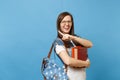 Portrait of young overjoyed laighing woman student in glasses with backpack holding books, pointing index finger on copy