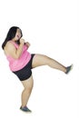 Young overweight woman performing a kick