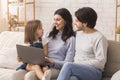 Portrait of young parents and their little daughter using laptop together Royalty Free Stock Photo