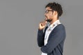 portrait of young pensive african american man posing in glasses wearing jumper touching chin looking sideways, isolated Royalty Free Stock Photo