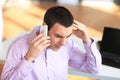 Portrait of young pensive businessman talking on cell phone in o Royalty Free Stock Photo