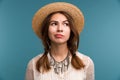 Portrait of a young pensive girl in summer hat isolated over blue background, Royalty Free Stock Photo