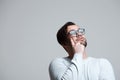 Portrait of young pensive man wearing blue glasses over white background