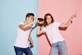 Portrait of young people, man and woman looking in binoculars isolated over blue-pink background. Tourists, travelling Royalty Free Stock Photo