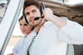 Portrait of young pilot and beautiful stewardess inside airplane cabin Royalty Free Stock Photo