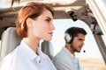 Portrait of young pilot and beautiful stewardess inside airplane cabin Royalty Free Stock Photo