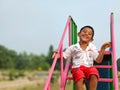 Portrait of a young playful Indian boy sitting on the stairs of a playground Royalty Free Stock Photo