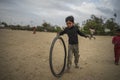 Portrait of young poor kid playing with bicycle wheel in India Royalty Free Stock Photo