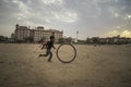 Portrait of young poor kid playing with bicycle wheel in India Royalty Free Stock Photo