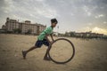 Portrait of young poor kid playing with bicycle wheel in India Royalty Free Stock Photo