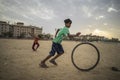 Portrait of young poor kid playing with bicycle wheel in India Royalty Free Stock Photo