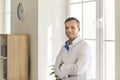 Portrait of young positive man office worker manager in white official shirt