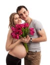 Portrait of young pregnant couple holding flowers Royalty Free Stock Photo