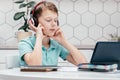 Portrait of young boy sitting near notebooks in front of tablet, listening to online lesson, music with closed eyes. Royalty Free Stock Photo