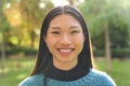 Portrait of young pretty asian woman smiling and looking at camera outdoors. Happy Chinese girl. Royalty Free Stock Photo