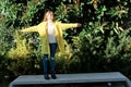 Portrait of a young pretty Caucasian girl, dressed in a yellow jacket, a white sweater, with her hair in the wind climbing on a Royalty Free Stock Photo