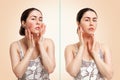 Portrait of a young pretty caucasian woman showing redness and inflamed blood vessels on her cheeks. Beige background. The concept