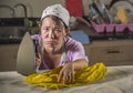 Portrait of young pretty frustrated and stressed Asian Korean woman working at home kitchen ironing clothes desperate and overwhel Royalty Free Stock Photo