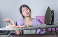 Portrait of young pretty frustrated and stressed Asian Korean woman working at home kitchen ironing clothes desperate and overwhel