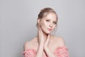 Portrait of young pretty gentle blonde woman with updo hairdo on white background