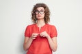 Portrait of a young pretty girl in a red dress and glasses with an emotional expression of resentment. Pout her lips