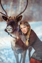 Portrait of a young pretty girl with a reindeer