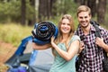 Portrait of a young pretty hiker couple holding a sleeping bag and backpack