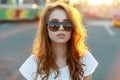 Portrait of a young pretty hipster woman`s face in stylish sunglasses with red curly hair in a stylish T-shirt Royalty Free Stock Photo