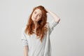 Portrait of young pretty redhead girl with freckles looking at camera smiling touching hair over white background. Royalty Free Stock Photo