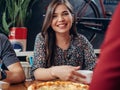 Portrait of young pretty smiling woman looking at camera sitting in restaurant drinking coffee and eating pizza with