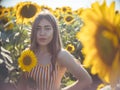 Portrait of young pretty woman agronomist standing on background of field with sunflowers, she looks at camera Royalty Free Stock Photo