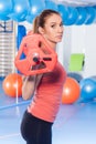 Portrait of a young pretty woman holding crossfit barbell and doing fitness indor. Crossfit hall. Gym shot.