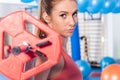 Portrait of a young pretty woman holding crossfit barbell and doing fitness indor. Crossfit hall. Gym shot.