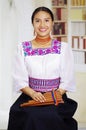 Portrait of young pretty woman wearing beautiful traditional andean clothing, sitting down with while playing the Royalty Free Stock Photo