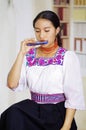 Portrait of young pretty woman wearing beautiful traditional andean clothing, sitting down with while playing the Royalty Free Stock Photo