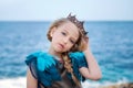 Portrait of a young princess girl in a crown and azure dress is tilted her head and looks tenderly Royalty Free Stock Photo