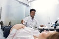 Portrait of young professional male African American doctor obstetrician, using ultrasound scanner and screening belly Royalty Free Stock Photo