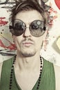 Portrait of young punk in round sunglasses