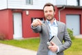 Portrait of a young real estate agent in front of a house