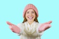 Portrait of a young red-haired teenager girl in a knitted pink hat and knitted pink mittens, arms outstretched to the Royalty Free Stock Photo