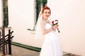 Portrait of young redhead bride with bouquet of roses. Royalty Free Stock Photo