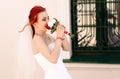 Portrait of young redhead bride with bouquet of roses. Royalty Free Stock Photo