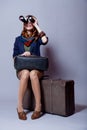 Young redhead girl with suitcase and binocular Royalty Free Stock Photo