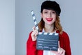Woman in red cardigan and hat with clapboard Royalty Free Stock Photo
