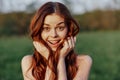 Portrait of a young redheaded woman looking into the camera and smiling, close-up portrait of a laughing woman in the Royalty Free Stock Photo