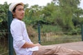 Portrait of young relaxed man sitting on the floor in out door background. Royalty Free Stock Photo