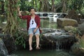 Portrait of a young relaxed man sitting near waterfall Royalty Free Stock Photo
