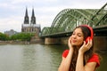 Portrait of young relaxed woman listening to music with urban background. City girl with red headphone enjoying music outdoors. Royalty Free Stock Photo