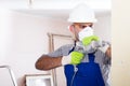 Portrait of young repairer man standing with drill indoors