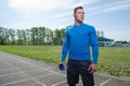 Portrait of a young runner in headphones at the stadium